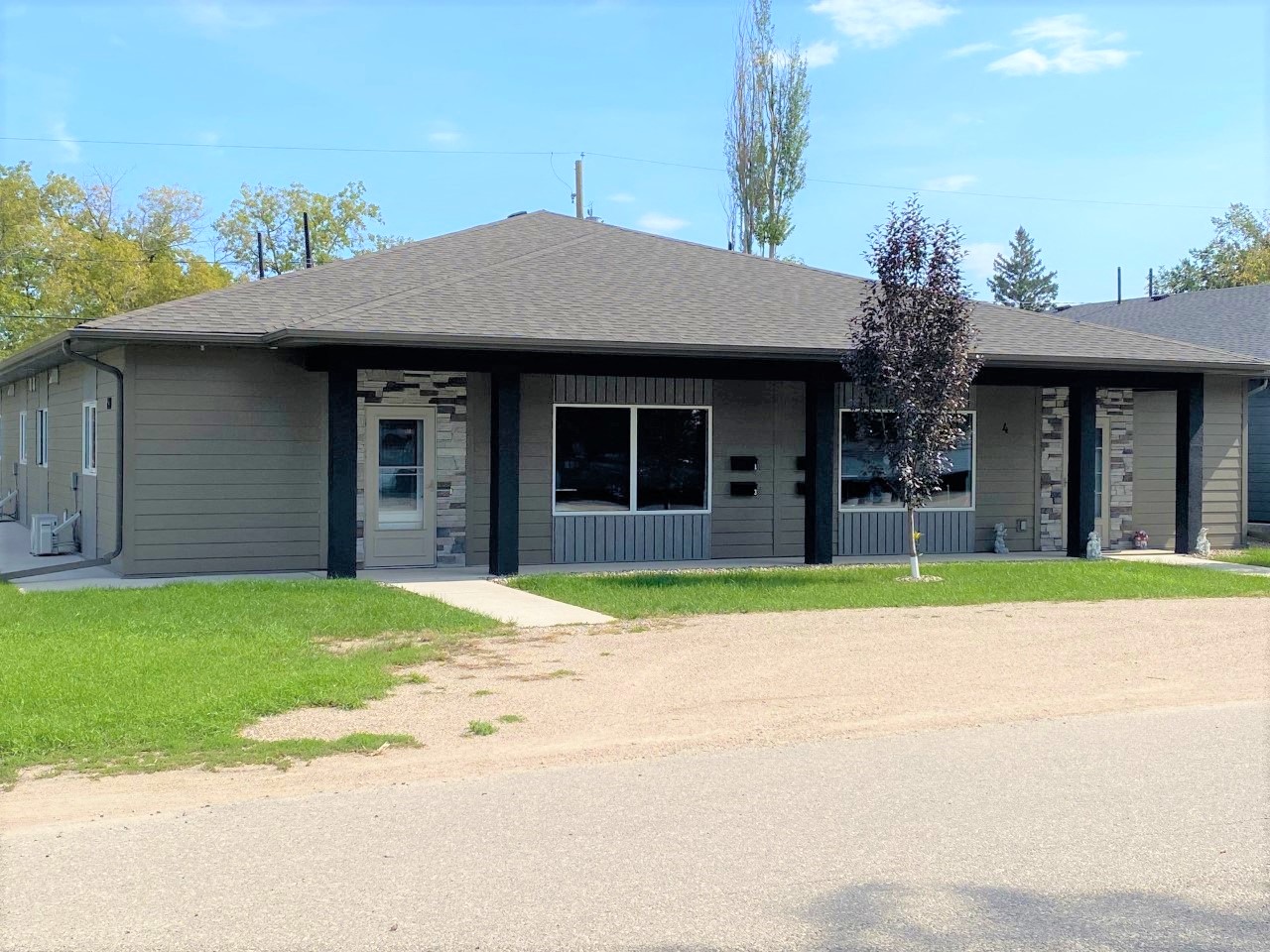 a gray building with a tree in front of it